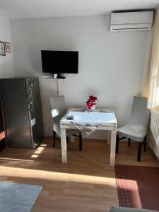 a room with a table and two chairs and a television at Studio apartman Dora in Vinkovci