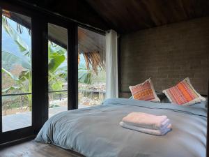 a bedroom with a bed with two towels on it at La Maison SAPA - Bungalows in Sa Pa
