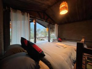La Maison SAPA - Bungalows في سابا: غرفة نوم بسرير كبير ونافذة