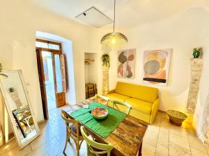 un soggiorno con tavolo e divano giallo di Luxury Trulli with Terrace ad Alberobello