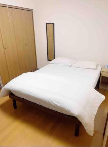 ZY House في أوساكا: سرير بشرشف ووسائد بيضاء في الغرفة