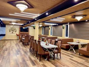 a restaurant with tables and chairs in a room at Hotel Rollingrang in Kalpa