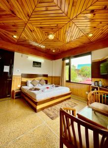 um quarto com uma cama e um tecto de madeira em Hotel Rollingrang em Kalpa