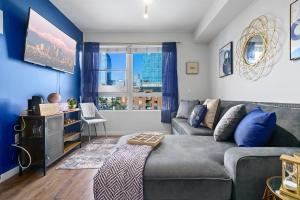 sala de estar con sofá gris y paredes azules en DTLA Escape Skyline views with luxury amenities, en Los Ángeles