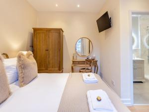 a bedroom with a bed with two towels on it at Rose Cottage - Uk45497 