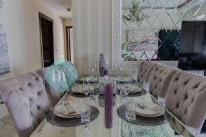 uma mesa de jantar com cadeiras e uma mesa de vidro em Grandeur 3 Bedroom In Wave em Abu Dhabi