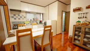 a kitchen with a table and chairs in a room at AMAMI-Green-Garden in Amami