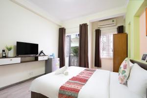 a hotel room with a bed and a tv at Planet Homestay in Ho Chi Minh City