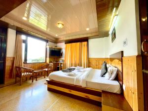 um quarto com uma cama e uma mesa num quarto em Hotel Rollingrang em Kalpa