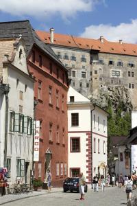 a group of people walking down a street with buildings at Largo in Český Krumlov