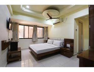 1 dormitorio con 1 cama y ventilador de techo en Hotel Janki Guest House, Jamnagar, en Jamnagar