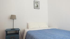 リスボンにあるCasa De Baixoのベッドルーム1室(ベッド1台、ランプ付きテーブル付)