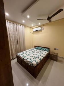 1 dormitorio con 1 cama y ventilador de techo en Shrinath Palace en Deoghar