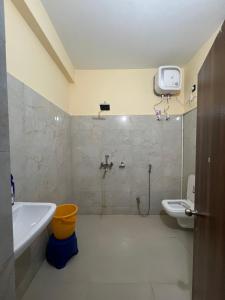 uma casa de banho com um chuveiro, um lavatório e um WC. em Shrinath Palace em Deoghar