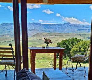 a table with a vase on it on a porch with a view at Berghouse and Cottages in Langkloof