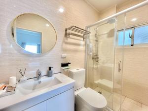 uma casa de banho com um WC, um lavatório e um espelho. em 沙沙民宿 em Magong