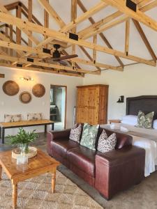 a living room with a couch and a bed at Berghouse and Cottages in Langkloof
