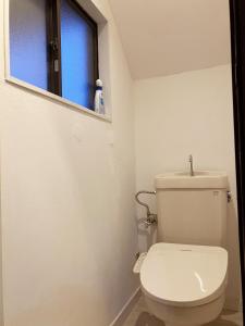 a white toilet in a bathroom with a window at 南箱根 熱海 貸切別荘 リゾートハウス トモ in Atami +30 photos