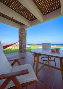 a porch with a table and chairs on a patio at Cristelia seafront & pool villa in Lakhania