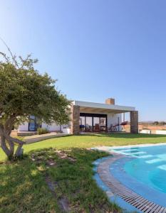 een huis met een zwembad ervoor bij Cristelia seafront & pool villa in Lachaniá