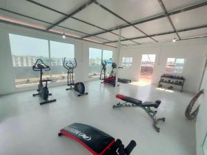 a gym with several exercise equipment in a room with windows at PRL Place in Bangkok