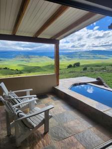 a patio with a chair and a swimming pool at Berghouse and Cottages in Langkloof