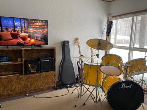 a living room with a drum set and a guitar at Alpha Live Madarao in Madarao Kogen