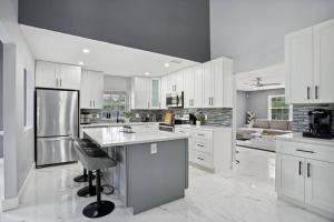 a large kitchen with white cabinets and a chair in it at Escondida Drive in West Palm Beach