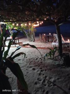 un tavolo e sedie su una spiaggia di notte di Akoya Beach Park and Cottages a Locaroc
