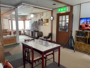 a living room with a table and chairs in a room at Alpha Live Madarao in Madarao Kogen