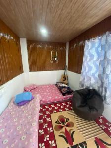 Habitación pequeña con 2 camas y ventana en Shrubbery Homestay and Guest house, en Darjeeling