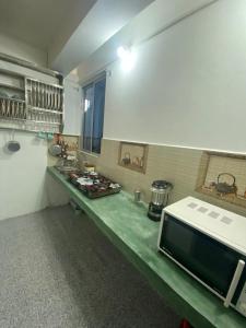 cocina con encimera y microondas en Shrubbery Homestay and Guest house, en Darjeeling