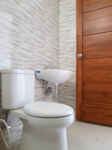 a bathroom with a white toilet and a sink at Kencana residence by holistic group in Jimbaran