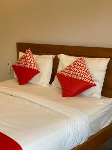 2 almohadas rojas y blancas sentadas en una cama en Kencana residence by holistic group en Jimbaran
