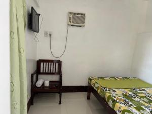 a small bedroom with a bed and a shower at Jancas Vacation Home Camiguin Couple Room 2 in Catarman
