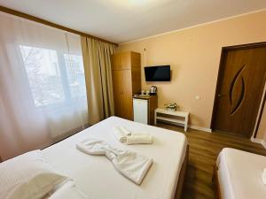 a hotel room with two beds and a window at Vila La Famiglia in Eforie Nord