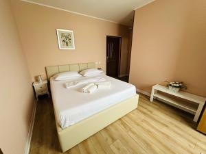 a bedroom with a bed with white sheets and pillows at Vila La Famiglia in Eforie Nord