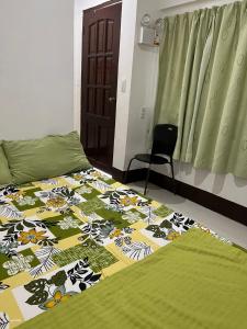a bedroom with a bed with a quilt on it at Jancas Vacation Home Camiguin Couple Room 2 in Catarman