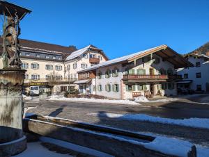 a building with a statue next to a street at Ferienwohnung Jodlschmid in Ruhpolding