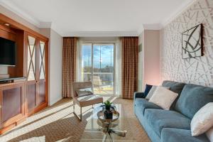 a living room with a blue couch and a glass table at Serenity Suite in Las Vegas