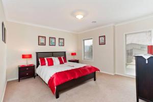a bedroom with a large bed with red pillows at Large family getaway in Torquay