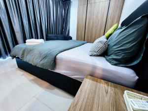 ein Schlafzimmer mit einem Bett mit grünen Kissen darauf in der Unterkunft Kozi Square Twin Room with free Wi-fi & Carpark in Kuching