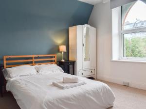 a bedroom with a large white bed with a window at Houndsfield in Ilfracombe