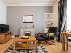a living room with two chairs and a fireplace at Armadale Apartment in Fort William