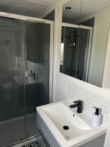 a bathroom with a white sink and a shower at Island Coorie in Kilmaluag