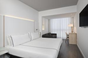 a hotel room with a white bed and white walls at Innside by Melia Palma Center in Palma de Mallorca