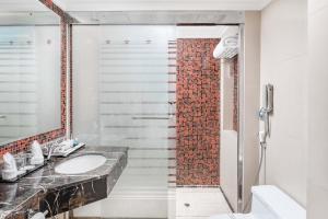 a bathroom with a sink and a shower at Al Aqeeq Madinah Hotel in Al Madinah