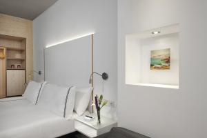 Habitación blanca con cama con almohadas blancas en INNSiDE by Meliá Palma Center, en Palma de Mallorca