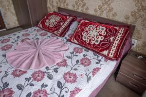 a bed with two pillows on top of it at Guest House Jekshen in Imeni Karla Marksa