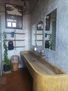 eine große Holzbadewanne in einem Badezimmer mit Spiegel in der Unterkunft Vin vin in Ubud